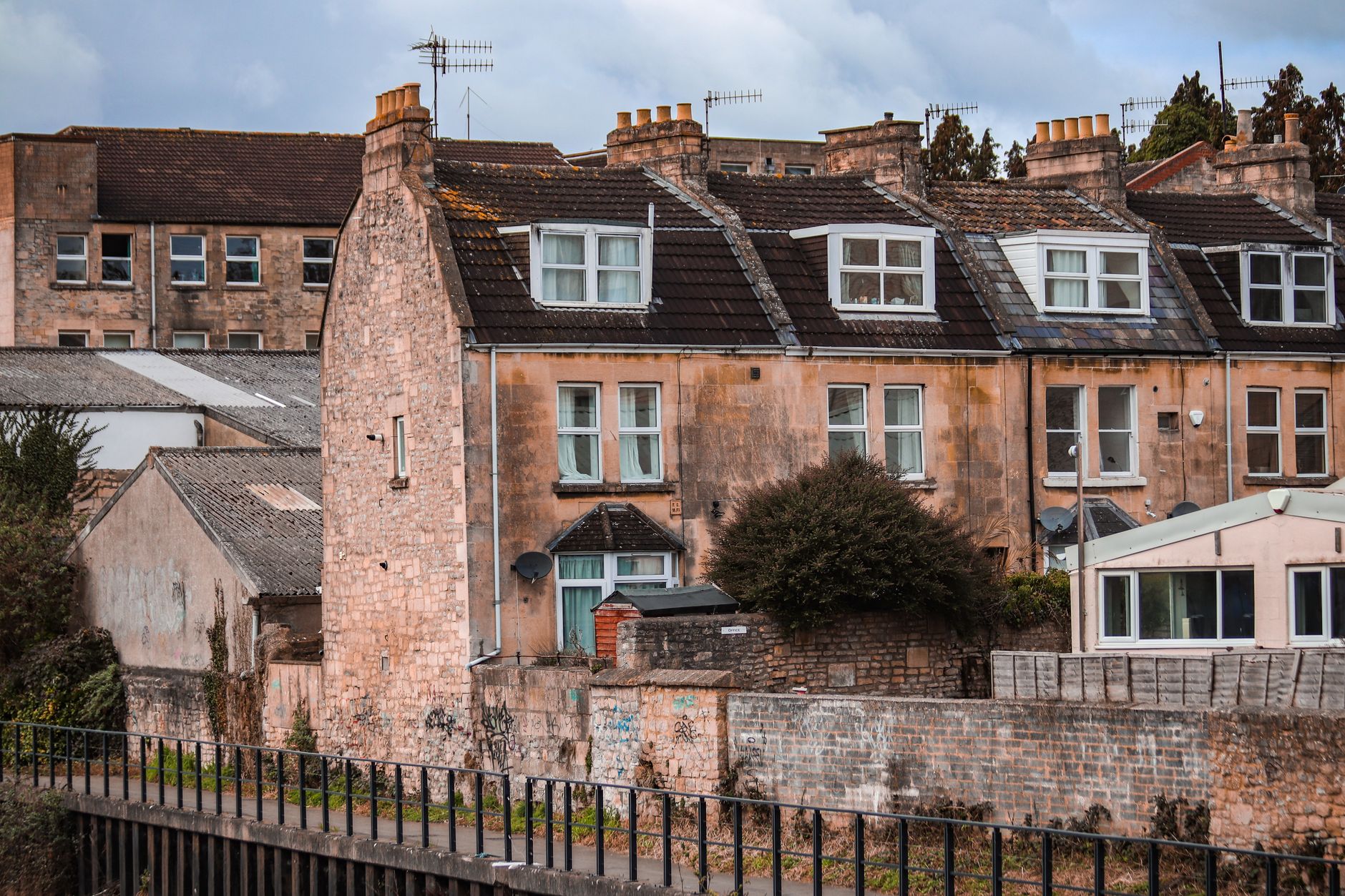 Row of Victorian terrace rooftops in Leeds with Yorkshire stone slates, brick chimney stacks and lead flashing